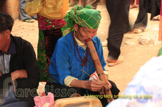 A Hmong lady smoking tobacco on pipe