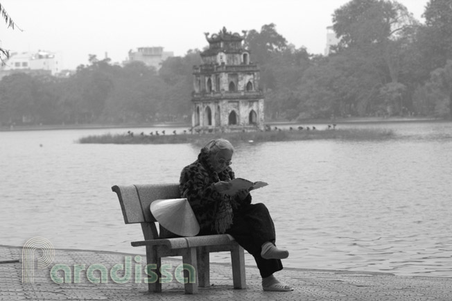 Reading by the turtle tower on the Hoan Kiem Lake in Hanoi