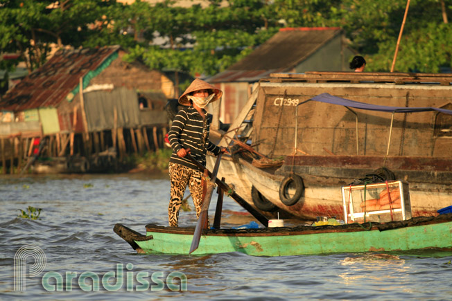 Une dame rame sur le fleuve Mékong au sud du Vietnam