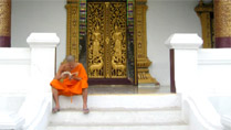 A young buddhist monk reading at Luang Prabang