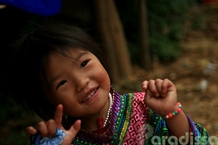 A little Hmong girl at Can Cau Market attracted by the new clothes