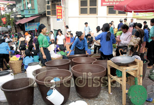 Des dames Nung vendent des contenants d'eau au marché Hoang Su Phi