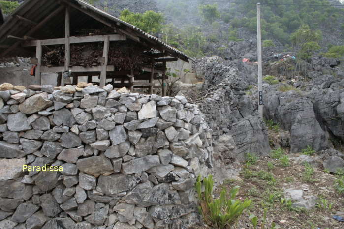 A Hmong house with walls made of stacked pieces of stone