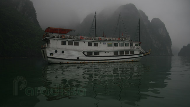 A junk navigating through the fog on Halong Bay