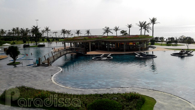 A long swimming pool right by the sandy beach