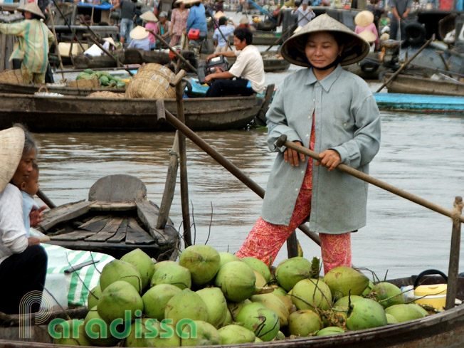 A lady and on her coconut boat at Cai Be Floating Market