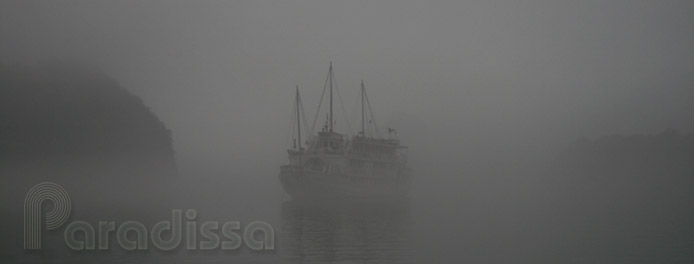 A junk on Halong Bay in thick fog in the early morning