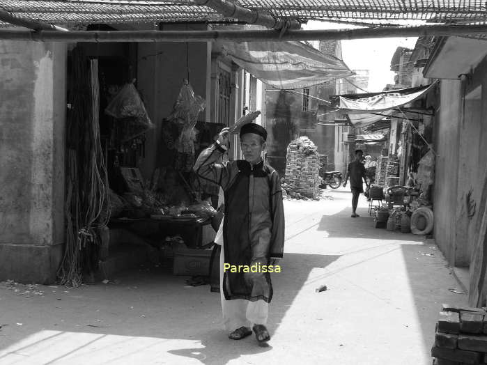 An old man in traditional costumes at the Tho Ha Village