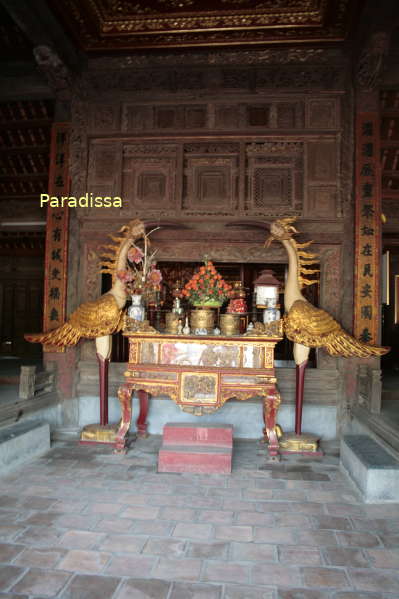 A pair of cranes standing on turtle in front of the altar at the Dinh Bang Communal House