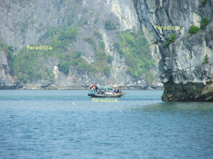 A fishing boat amid the spectacular mountains and islands of Halong Bay