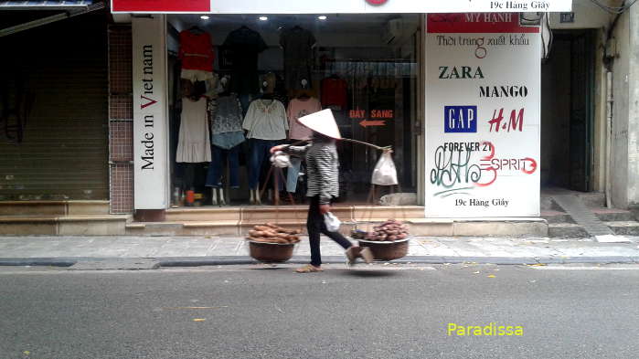 A street vendor in front of a shop in Hanoi